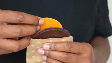 Bir insan çikolata ve meyveden yapılmış tatlı bir aperatif tutar..