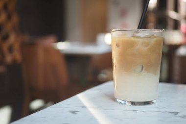 Gün boyunca bir kafede bir bardak buzlu kahve bir masada oturur..