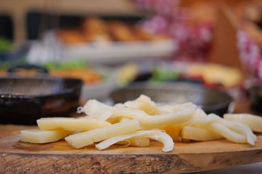 Tahta bir pazar etkinliğinde taze peyniri dilimlere ayırır..