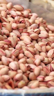 Fıstık fıstıkları pazar ortamında sergilenir. Müşteriler onlara bakar..