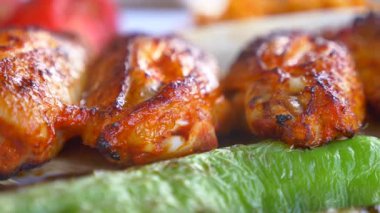 Tavuk kanatları sıcak bir günde taze sebzelerin yanında kızartılır..