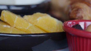 İnsanlar sabah yemeğinde portakal dilimleri ve atıştırmalıkları paylaşırlar..