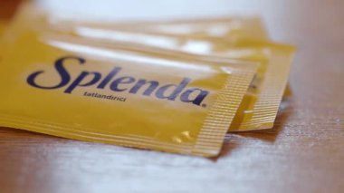 Yakın plan, şeker yerine kullanılan paketleri ahşap bir masada gösteriyor..