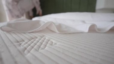 Çarşaf ve yastıkların evdeki bir yatakta dizilişini izle..