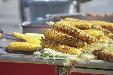 Tedarikçiler marketteki müşteriler için taze kızarmış mısır hazırlıyorlar..