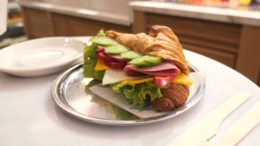 Sebze ve etle dolu bir kruvasan sandviçin tadını çıkar..