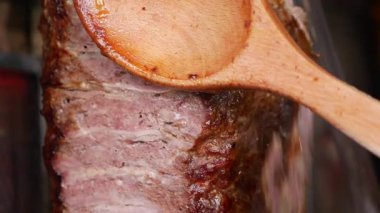 Biftek ızgarada pişirilirken ahşap kaşık da onu pişirmek için kullanılıyor..