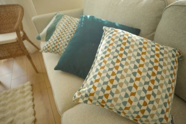 Dört yastık parlak bir oturma odasındaki bir kanepede dizilir..