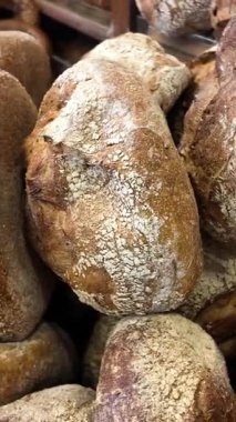 İnsanlar fırından çıkan sıcak ekmeği seyrediyorlar..