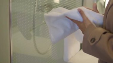 Bir kadın tuvalette ellerini havluyla kurutuyor..