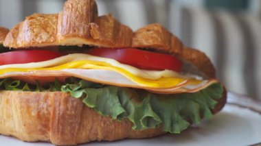 Sandviç kruvasan, peynir, marul ve domatesle yapılır..