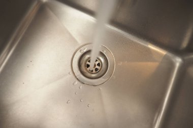 Su musluktan evdeki paslanmaz çelik lavaboya akıyor..