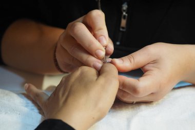 Bir kuaförde tırnak bakımı yapılan eller gösterilir.