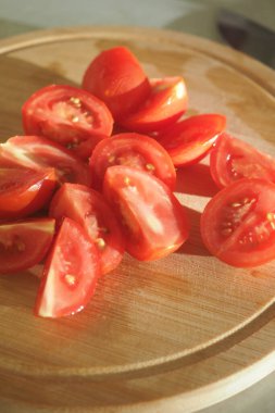 Domatesler, mutfağa yerleştirilmiş tahta bir tahtanın üzerinde birkaç parçaya ayrılır..