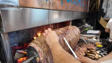 Şef, mutfakta alevlerin üstünde et pişiriyor..