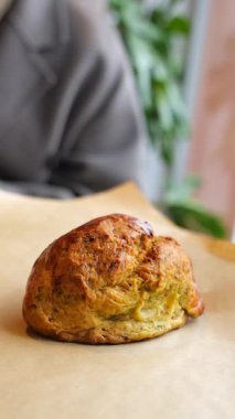 Bir insan bir masada oturur ve bir kafede sıcak pişmiş yemeğin tadını çıkarır.