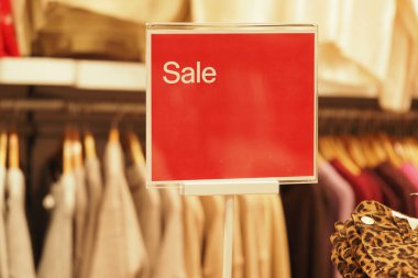 Bir mağazada elbise ve aksesuar satışını ilan eden bir tabela var..