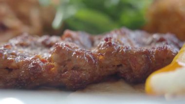 Taze yeşillik ve yanlarla servis edilen ızgara ete yakından bakın..