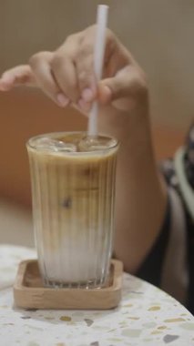 Süt ve buzla soğuk bir içeceğin tadını çıkarıyorum.