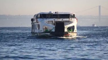 Güneş arka planda batarken suda bir tekne hareket ediyor..