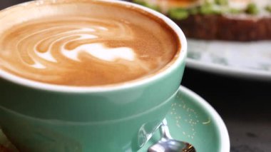 Kafedeki bir masanın üzerinde bir fincan kahve duruyor..