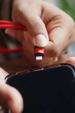 Birisi şarj kablosunu evdeki akıllı telefona bağlıyor..