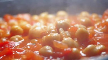 Nohut ve domatesler sobanın üstünde birlikte pişerler..