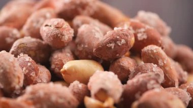 Bir masa yüzeyinde tuzla kaplı yer fıstıkları yığılır..