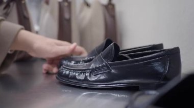 Marketten alışveriş yaparken siyah mokasen ayakkabılar alır..