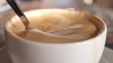 Bir barista sabahları bir kafede kahve karıştırır..