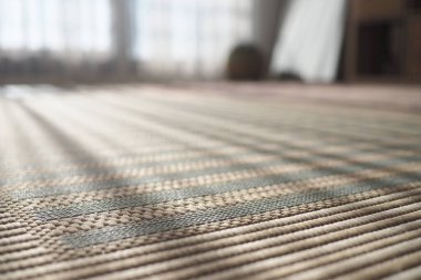 Odanın ahşap zeminine örülmüş bir halı konur..