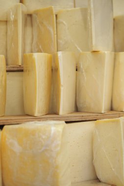 Peynir kalıpları, yaşlanmak için bir depoda, ahşap raflarda durur..