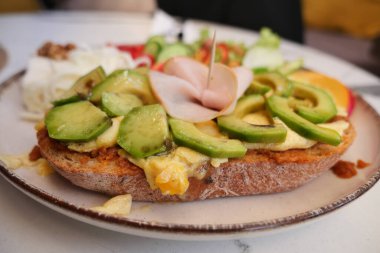 Peynirli sandviç, avokado, jambon ve salata..