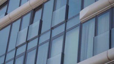 Yoğun bir şehir ortamında cam pencereli bir binanın görüntüsü.