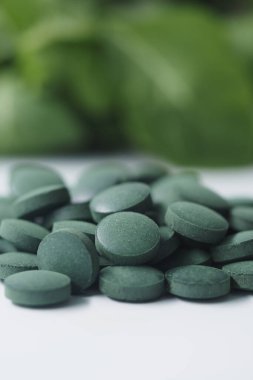 Tabletler arka planda yeşil yapraklarla düz bir yüzeye yerleştirilmiştir..