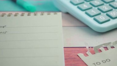 Yapılacak Notepad ve hesap makinesi planlama görevleri için ahşap bir tablo üzerinde.