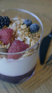 Yoğurt, granola, böğürtlen ve fındık katmanlı bir parfe gösterilir..