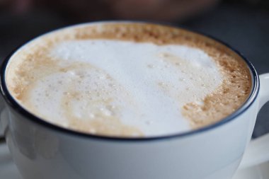 Sabahları süt köpüklü bir fincan kahve masada oturur..