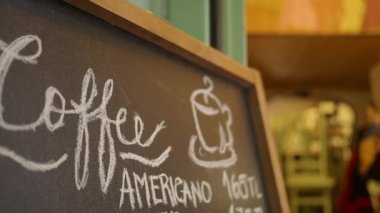 Bir karatahta küçük bir kafede kahve seçenekleri gösterilir.