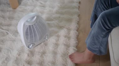 İçerideki yumuşak halıya çıplak ayakla oturan biri ısıtıcının yanına oturur..