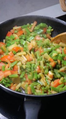 Yeşil fasulyeleri, domatesleri ve soğanları birlikte doğramak ve pişirmek.