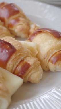 Bir tabak sıcak kruvasanları kahvaltı için hazır tutar..