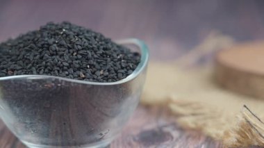 Siyah kimyon tohumları masada açık bir kasede gösterilir..