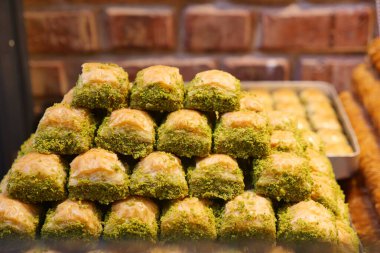 Baklava bir dükkanda, yeşil ve altın tabakalarını gösteriyor..