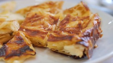 İnsanlar fırından peynirle dolu sıcak ve ince ekmeğin tadını çıkarıyorlar..