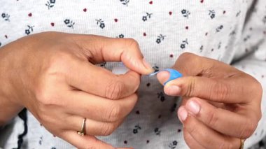 Parmağına mavi renk bandaj takıyor. .