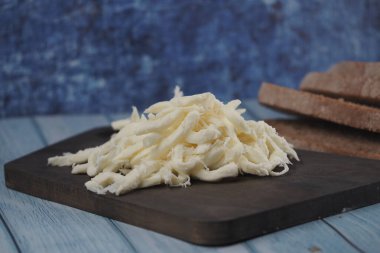 Paramparça peynir, tahta bir tahtanın üzerine, ekmek dilimlerinin yanına konur..