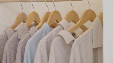Birkaç gömlek vitrindeki ahşap askılarda asılı..