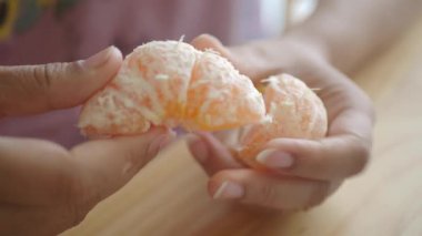 Bir insan mutfakta dilimlenmiş portakal tutar..