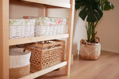 Köşede bir bitki dururken sepetler raflara konur..